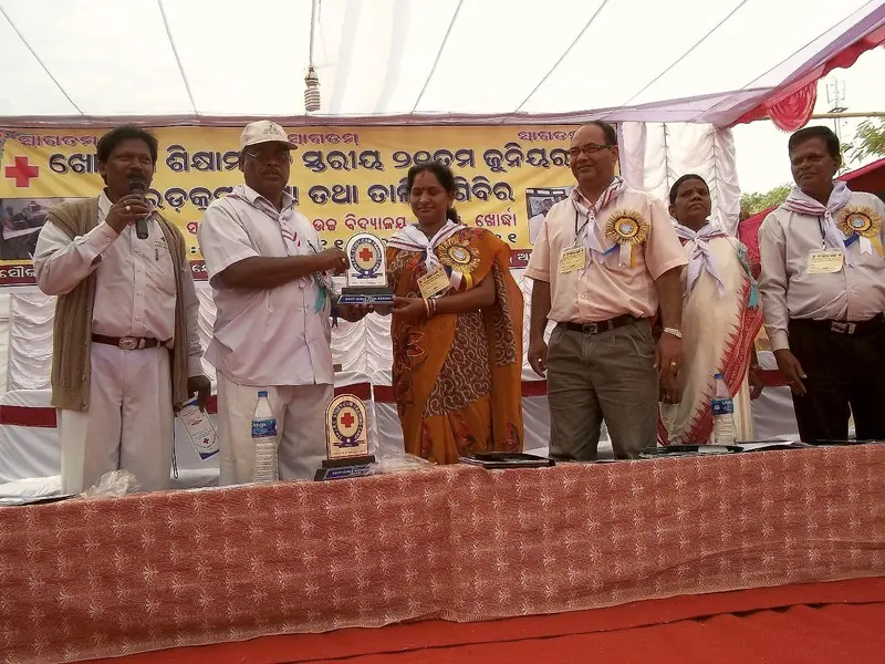 Volunteers and officials on stage at a Junior Red Cross training camp.