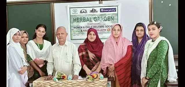 Students, teachers and WCWS members stand behind a "Herbal Garden" banner at Urdu Girls' High School, Cuttack.